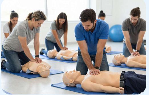 Students practicing CPR chest compressions on adult manikins